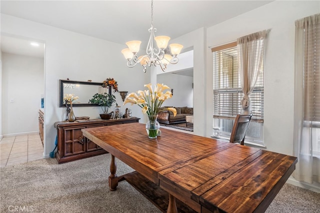 dining area featuring a chandelier and light colored carpet