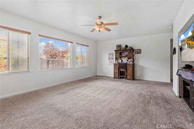 unfurnished living room featuring carpet flooring and ceiling fan