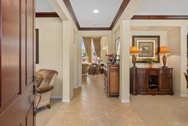 hall featuring ornamental molding, light carpet, and baseboards