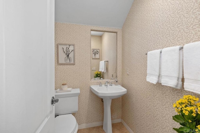 bathroom featuring baseboards, tile patterned floors, toilet, and wallpapered walls