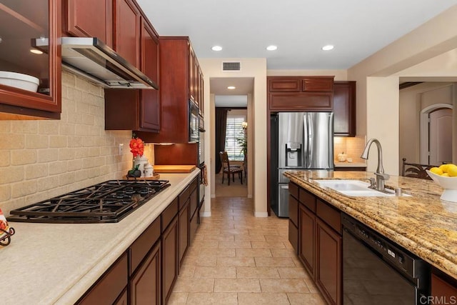 kitchen featuring extractor fan, a sink, visible vents, black appliances, and glass insert cabinets