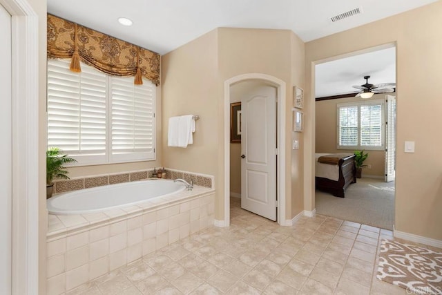 bathroom featuring visible vents, ceiling fan, tile patterned flooring, baseboards, and a bath