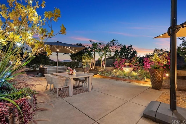 patio terrace at dusk featuring outdoor dining space