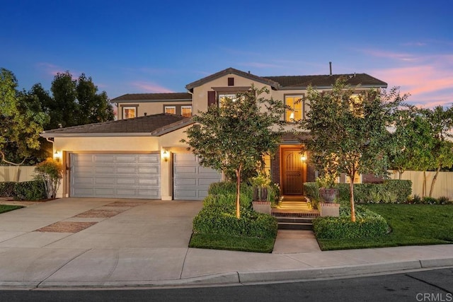 view of front of property featuring a garage, fence, driveway, and stucco siding