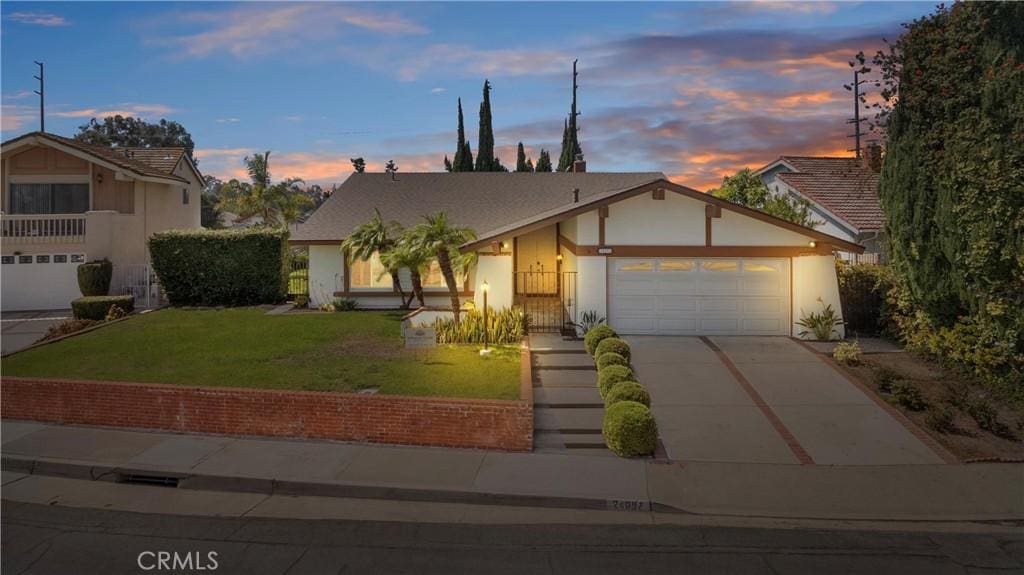 view of front of home with a garage and a yard