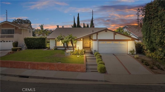 view of front of home with a garage and a yard