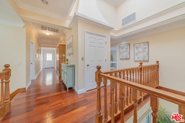 hallway with dark wood-type flooring and ornamental molding