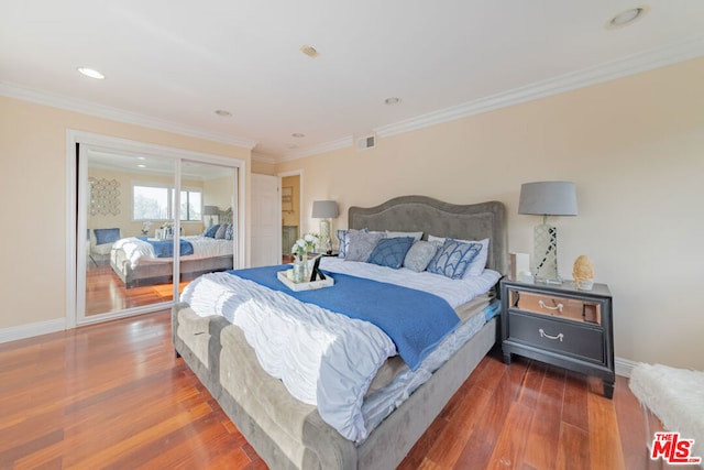 bedroom featuring dark hardwood / wood-style floors, a closet, and crown molding