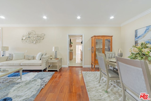 living room with wood-type flooring and ornamental molding