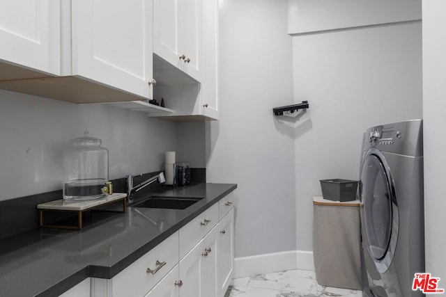 clothes washing area with cabinets, washer / clothes dryer, and sink