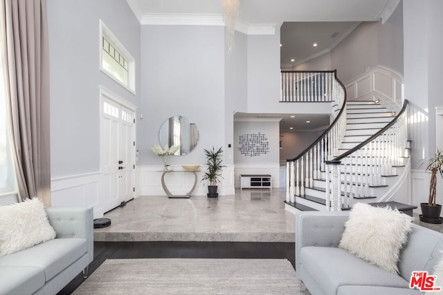 living room with a towering ceiling, dark hardwood / wood-style flooring, and crown molding