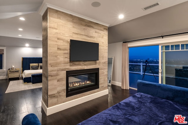 bedroom featuring dark hardwood / wood-style floors, access to exterior, and a large fireplace