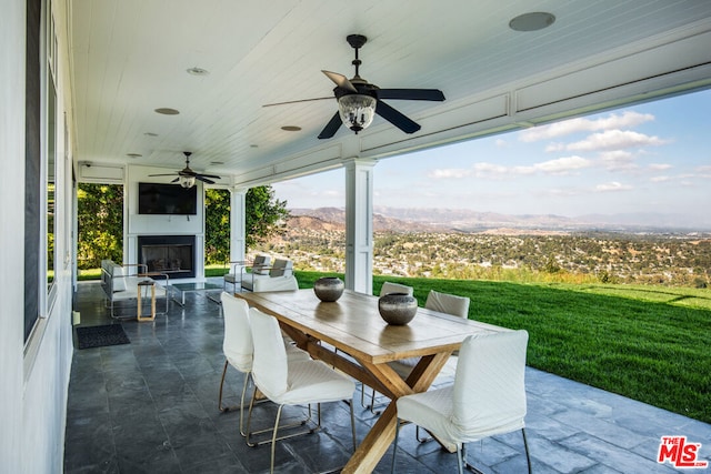 view of patio featuring exterior fireplace and ceiling fan