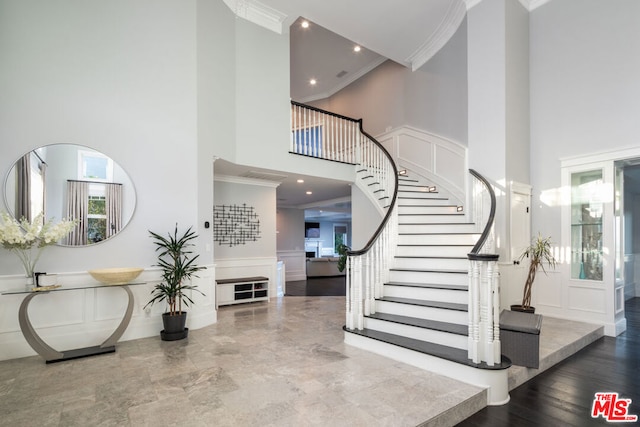 entryway featuring ornamental molding and a high ceiling