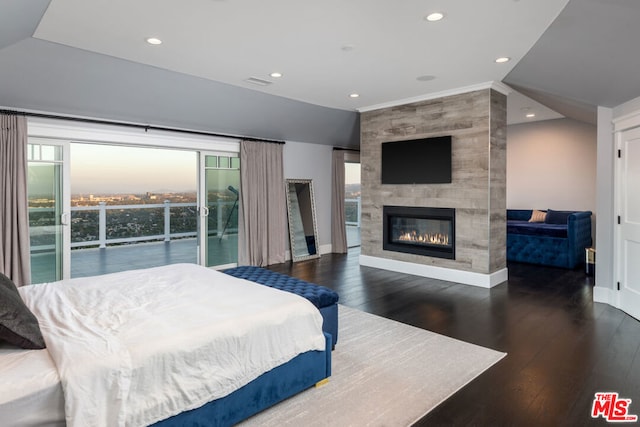 bedroom featuring access to outside, lofted ceiling, dark wood-type flooring, and a large fireplace