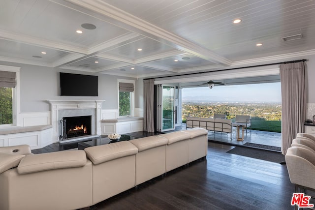 living room with crown molding, a fireplace, dark hardwood / wood-style floors, and plenty of natural light