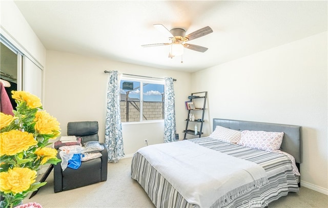 carpeted bedroom with ceiling fan and a closet