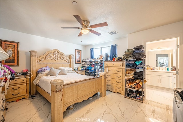 bedroom with a textured ceiling, ceiling fan, and ensuite bathroom