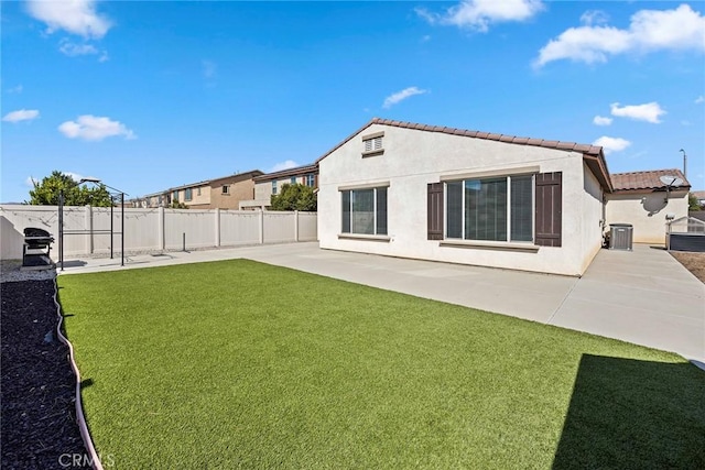 back of house with a lawn and a patio