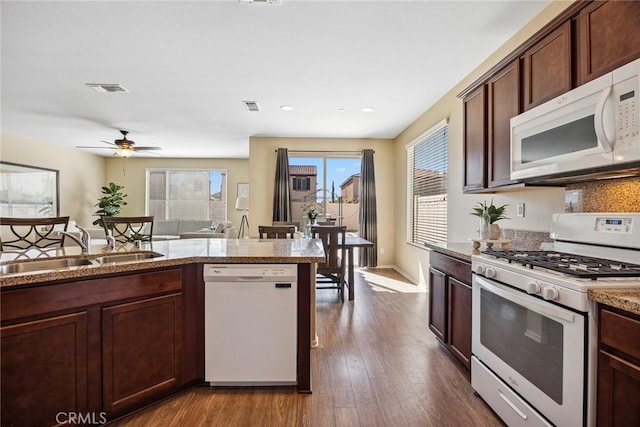 kitchen with white appliances, sink, dark hardwood / wood-style floors, ceiling fan, and dark brown cabinets