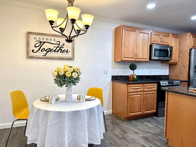 kitchen featuring pendant lighting, appliances with stainless steel finishes, dark hardwood / wood-style flooring, an inviting chandelier, and ornamental molding