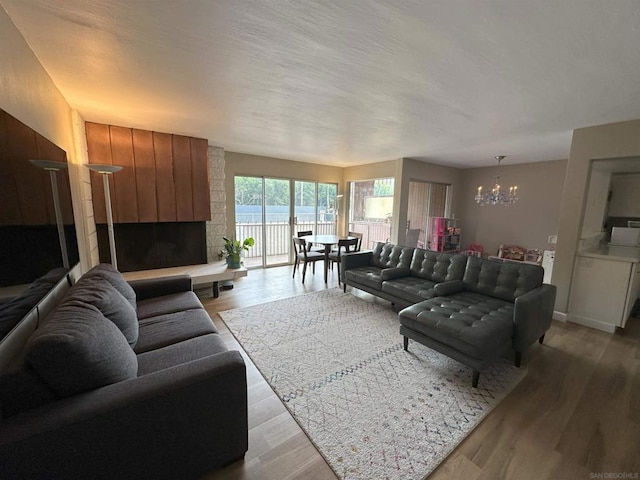 living room with an inviting chandelier and light wood-type flooring