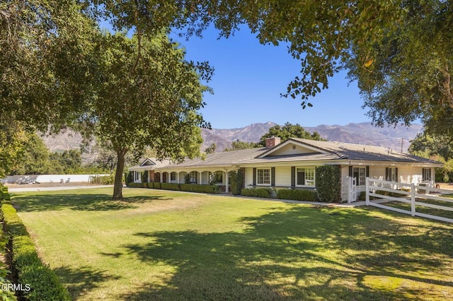 single story home with a mountain view and a front lawn