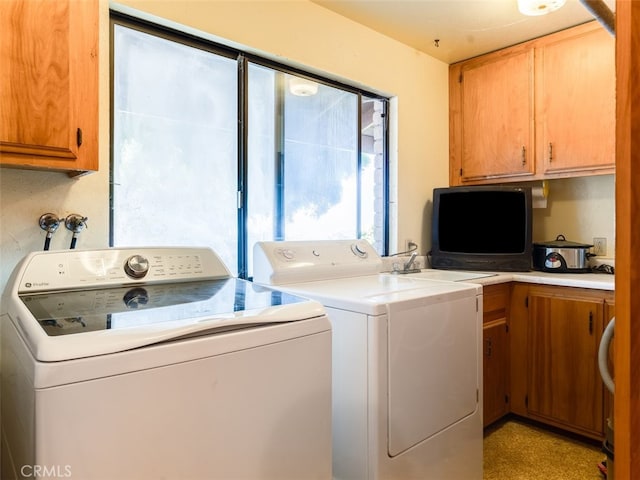 laundry room featuring cabinets and washer and clothes dryer