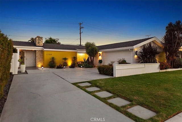 single story home with a lawn and a garage