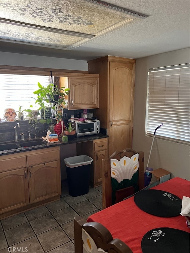 kitchen with tile patterned floors, sink, and a textured ceiling