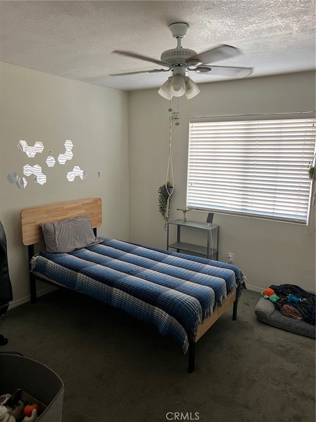 bedroom with ceiling fan, carpet floors, and a textured ceiling