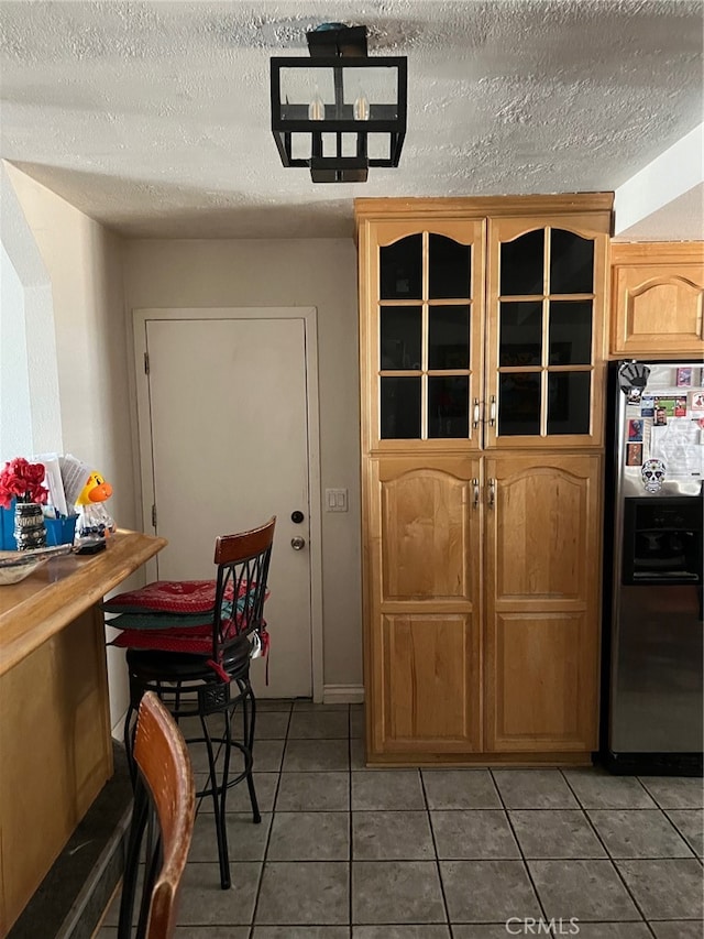 tiled dining room featuring a textured ceiling