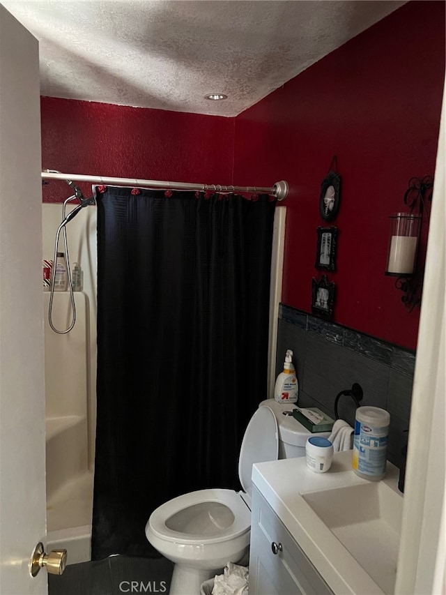 bathroom with vanity, toilet, and a textured ceiling