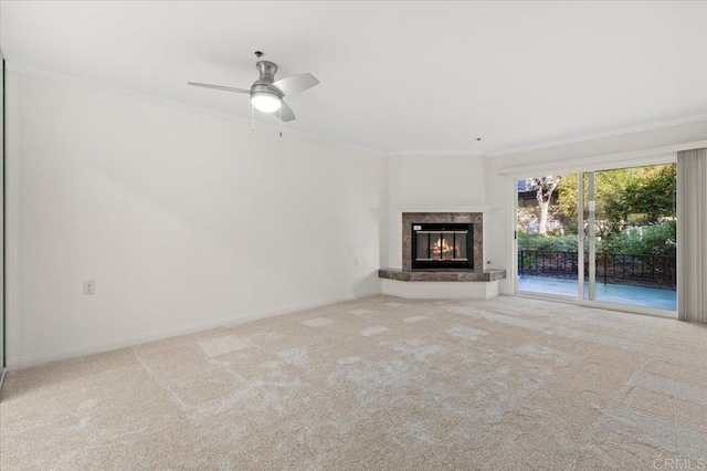 unfurnished living room featuring carpet flooring, ceiling fan, a high end fireplace, and ornamental molding