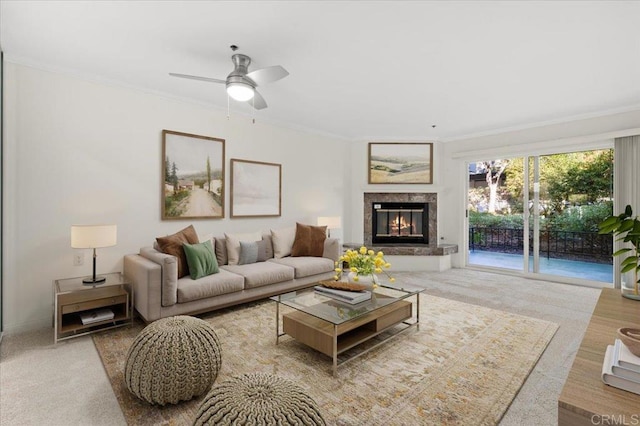 living room with hardwood / wood-style floors, ceiling fan, ornamental molding, and a premium fireplace