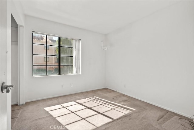 unfurnished room featuring light colored carpet