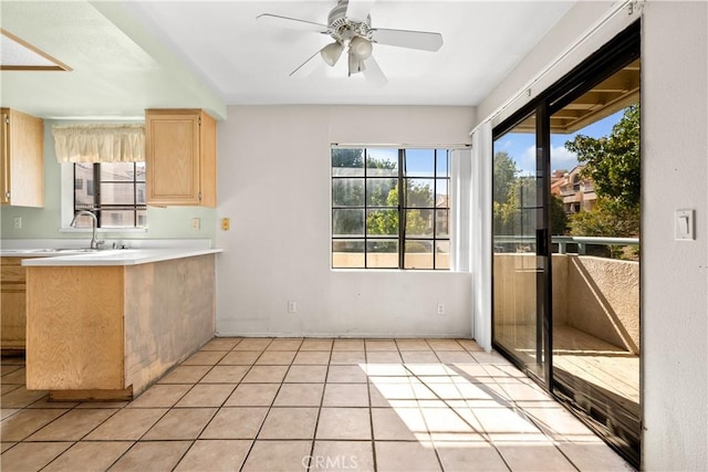 kitchen featuring ceiling fan, light brown cabinets, light tile patterned floors, and sink