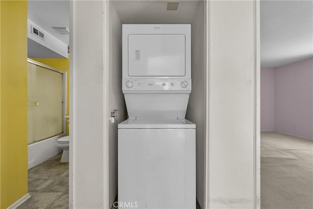 laundry area featuring stacked washer / dryer