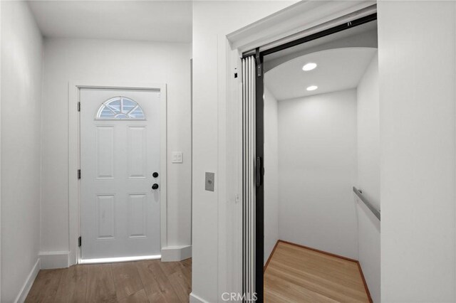 entryway with hardwood / wood-style flooring and elevator