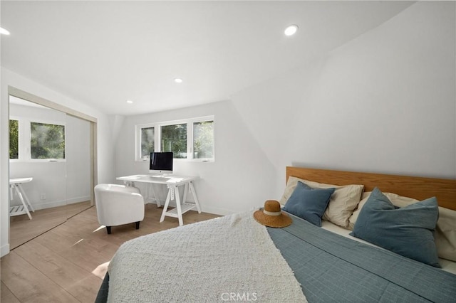 bedroom with vaulted ceiling and light hardwood / wood-style floors