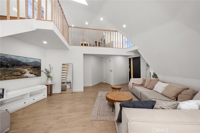 living room featuring light wood-type flooring and a high ceiling