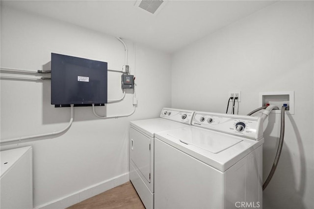 clothes washing area featuring light wood-type flooring and independent washer and dryer