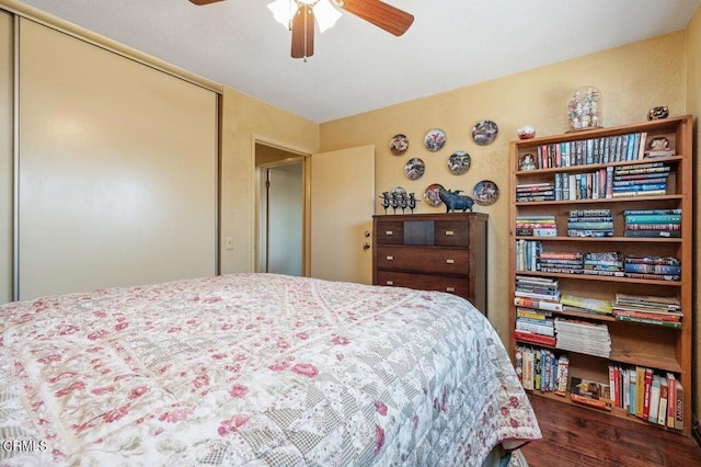 bedroom featuring a closet, dark hardwood / wood-style floors, and ceiling fan