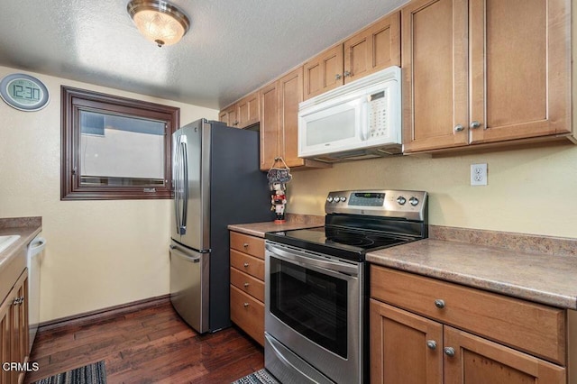 kitchen featuring appliances with stainless steel finishes, dark hardwood / wood-style floors, and a textured ceiling