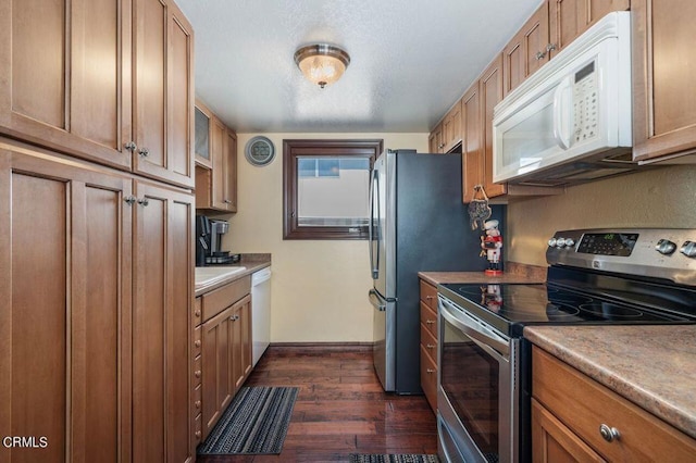 kitchen with dark hardwood / wood-style floors and white appliances