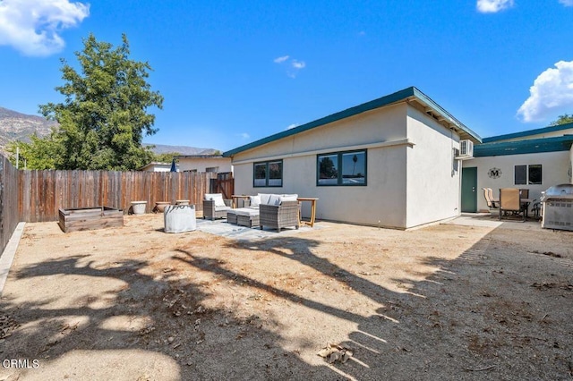 back of house featuring a patio area, a mountain view, and outdoor lounge area