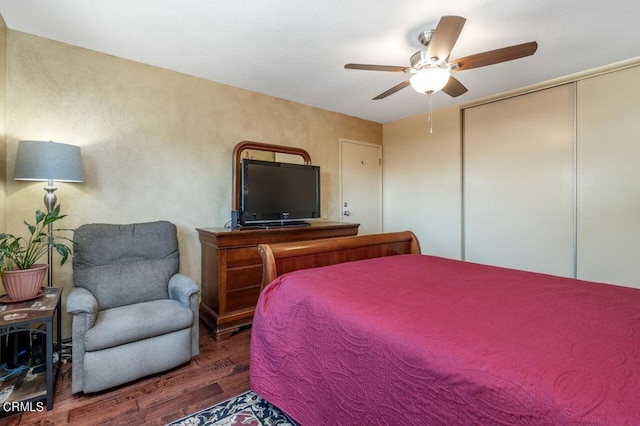 bedroom featuring dark wood-type flooring, ceiling fan, and a closet