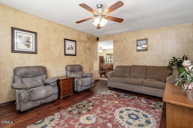 living room with ceiling fan and dark hardwood / wood-style flooring