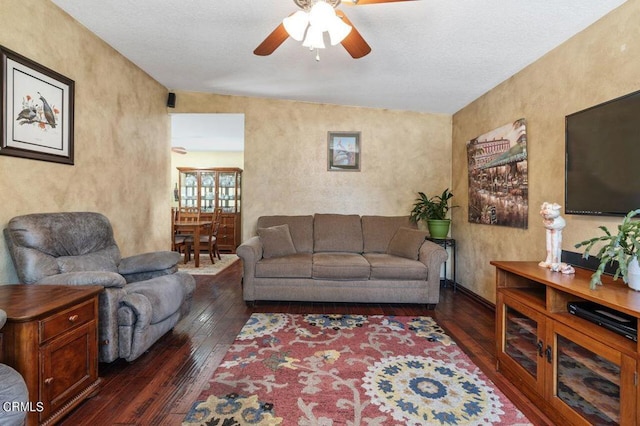 living room with dark wood-type flooring, ceiling fan, and lofted ceiling