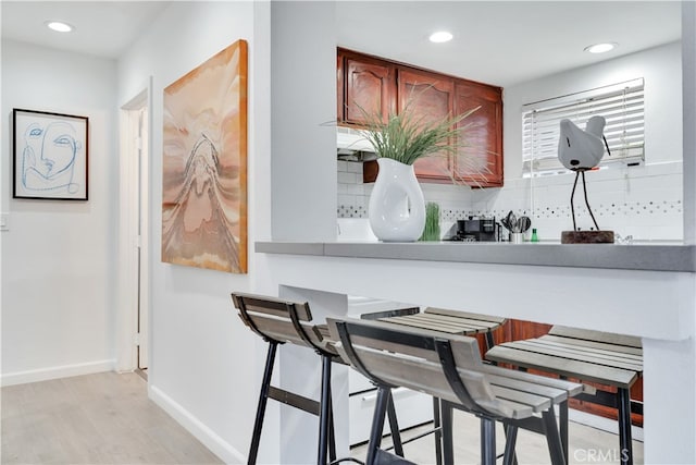 interior space with backsplash and light hardwood / wood-style floors